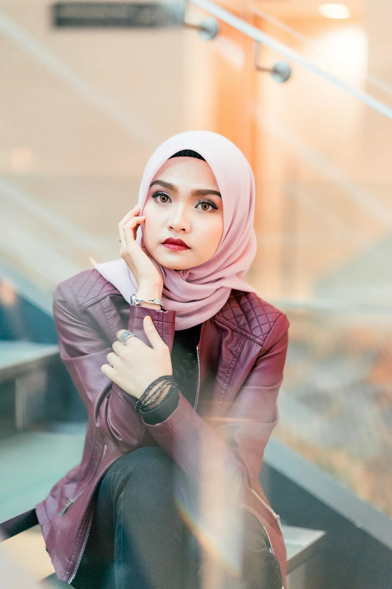 Outer kulit maroon di atas busana muslimah
